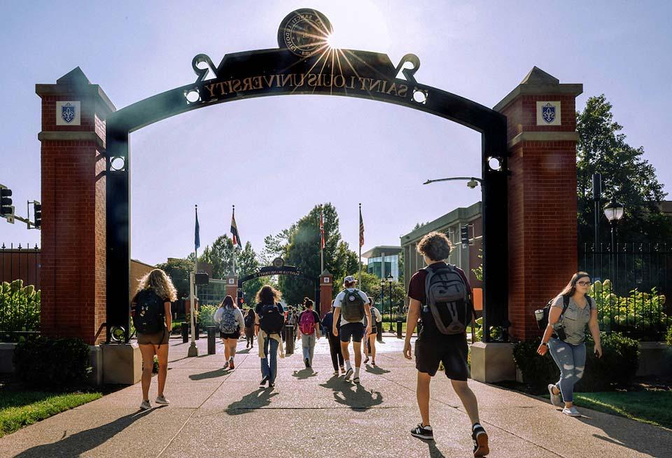 Students walk under the Saint Louis University archway on campus on the first day of classes.